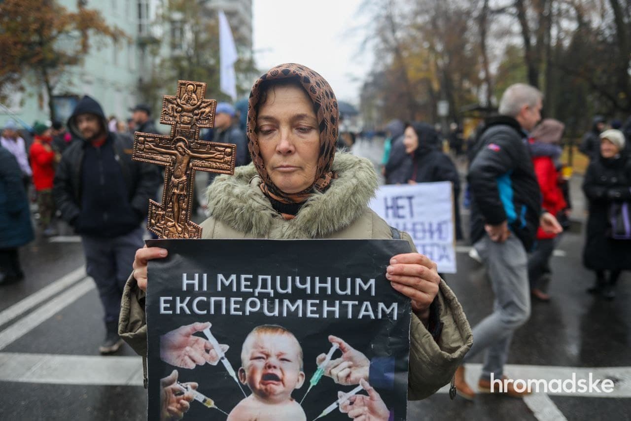 Протест антивакцинаторов в Киеве 3 ноября 2021 года. Женщина держит плакат, согласно которому, вакцинация детей понимается как медицинский эксперимент